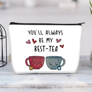 Detail view of canvas makeup bag with Best-Tea print on a light wooden surface