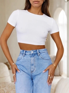 Slim fit white ribbed crop top t-shirt paired with light blue washed denim jeans