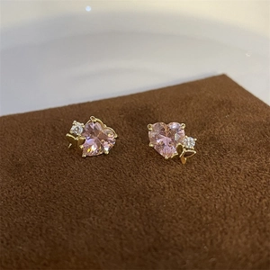 Detail showing heart-shaped pink zircon earrings with golden butterfly accents and gems