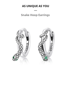 Macro detail of S925 sterling silver snake hoop earrings with green gemstone eyes