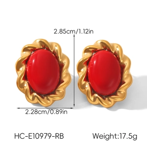 Detail of vintage French gold earrings with red oval stones and screw-thread texture