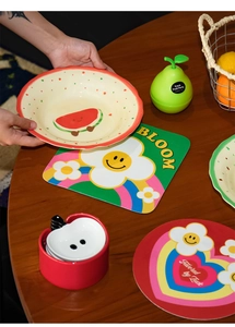 Close-up of colorful cartoon diatom mud placemats with fruit and flower designs on table