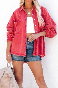 Detail of red distressed denim jacket featuring frayed hem, ripped holes and long sleeves