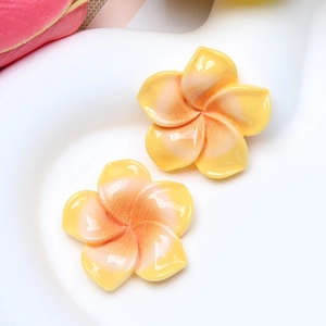 Close-up of yellow and orange gradient resin frangipani flower accessories for DIY crafts