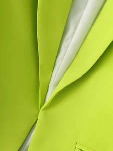 Gros plan du revers d'un blazer vert néon avec doublure blanche et texture tissée