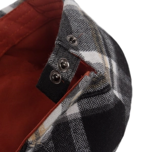 Herringbone flat cap with adjustable metal side buckles and contrasting orange lining