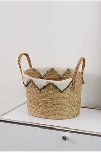Close-up of woven straw storage basket featuring white crochet trim and sturdy handles