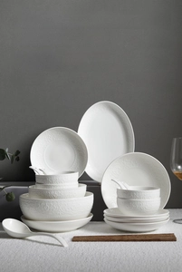 Detailed close-up of premium cream ceramic dinnerware set with embossed vine patterns
