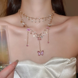 Close-up of double-layered gold necklace with pink resin butterflies and sparkling crystals