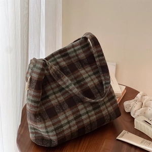 Gros plan du sac cabas en laine à carreaux rétro montrant la texture et le logo de marque