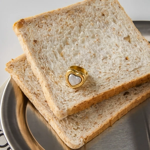 Detail of 18K gold stainless steel heart pearl ring displayed on creative toast setting
