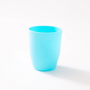 Minimalist sky blue travel mouthwash cup with matte texture and tapered plastic body