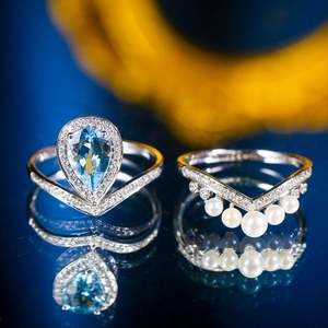 V-shaped silver ring set with light blue pear-shaped stone and white pearl drops