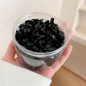 Thick black high-elastic disposable hair bands in a clear cylindrical storage jar