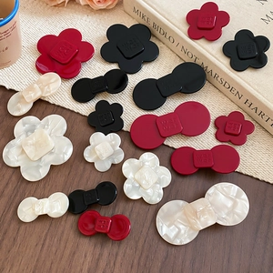 Macro detail of resin flower and bow hair clips with Wei Wei engraved lettering
