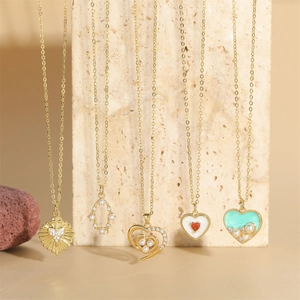 Golden heart pearl pendant necklaces collection displayed on beige marble surface
