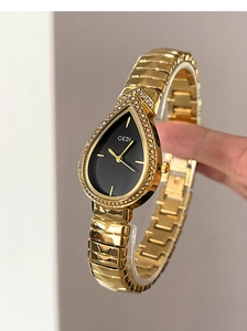 Close-up of gold pear-shaped watch with crystal bezel and elegant black dial detail