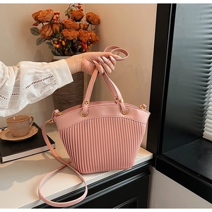 Pink pleated handbag with vertical stripe texture and gold hardware details