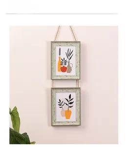 Close-up of dual hanging wood frames with hemp rope and minimalist botanical prints