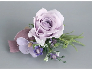 Macro detail of lavender silk rose boutonniere with velvet ribbon and green leaves