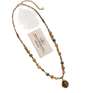 Collier perles bohème avec perles en verre turquoise et pendentif ambre sur fond blanc