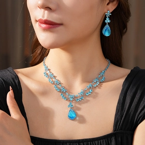 Vue détaillée du collier et des boucles d'oreilles avec gouttes bleues sur mannequin