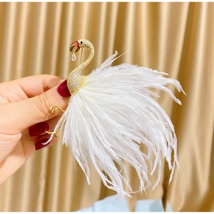 Elegant gold flamingo brooch with sparkling crystals and soft white feather textures
