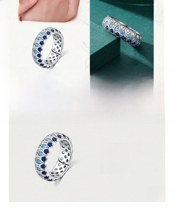 Detail view of 925 sterling silver ring with blue and white zircons in wave pattern