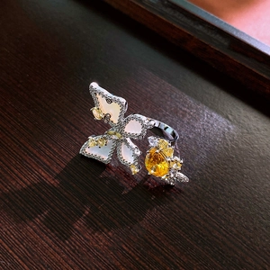 Macro shot of silver butterfly ring with mother of pearl wings and yellow zircon details
