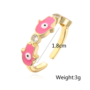 Detail of 18K gold-plated Hamsa Hand ring with pink enamel and sparkling zircon accents