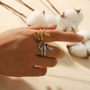 18K gold and silver snake ring with textured scales shown on a hand in a natural setting