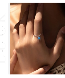 Close-up of s925 silver chain ring with a blue star-shaped pendant on a model hand