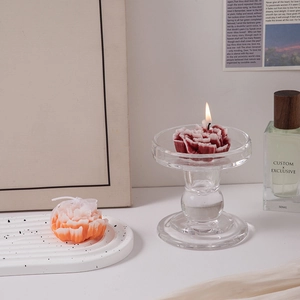 Close-up of red and orange carnation scented candles set in glass holders
