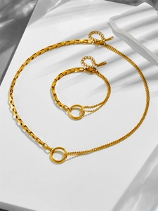 Dettaglio di set collana e bracciale in acciaio inossidabile dorato con marchio S.Steel