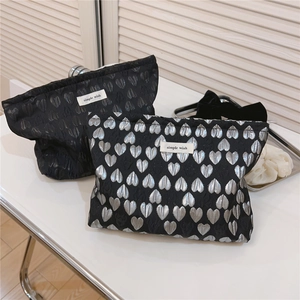 Detail of silver and black heart jacquard cosmetic bags with simple wish woven labels