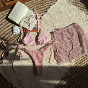 Detailed view of pink three-piece bikini set with mesh skirt and shimmer fabric finish