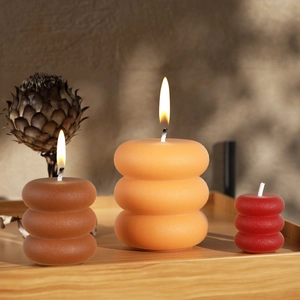 Close-up of three stacked ring pillar candles in brown and orange tones for home decor