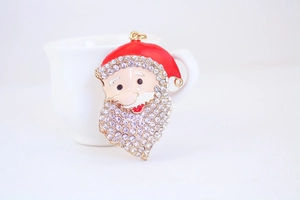 Macro detail of Santa Claus keychain featuring red enamel and sparkling rhinestones