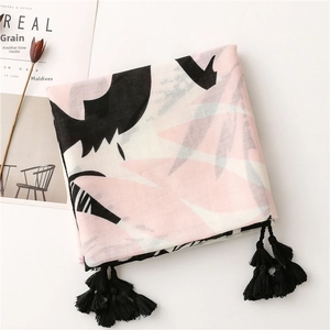 Detail of pink and black tropical leaf print scarf with elegant black tassels