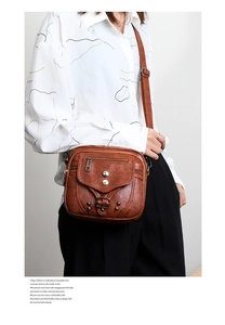 Sac bandoulière vintage marron en similicuir avec rivets et bandoulière réglable sur mannequin