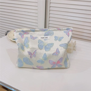 Detailed close-up of butterfly jacquard fabric and simple wish label on the cosmetic bag