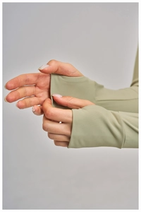 Détail de la manche d'une veste de yoga vert olive clair avec passant pour le pouce