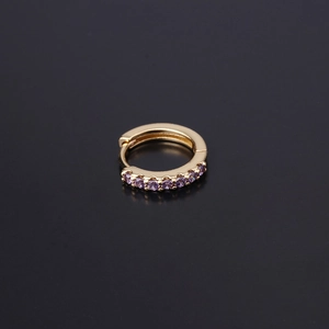 Macro shot of gold huggie earrings with seven purple cubic zirconia stones