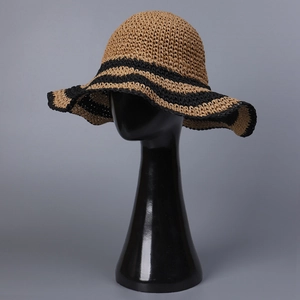 Handwoven wide brim straw sun hat with black wavy stripes for beach holiday on a mannequin