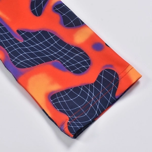 Détail du poignet avec imprimé flamme orange et motif à carreaux bleus sur maille