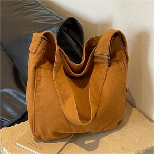 Large capacity canvas tote bag in tan with adjustable strap and side pocket for daily use