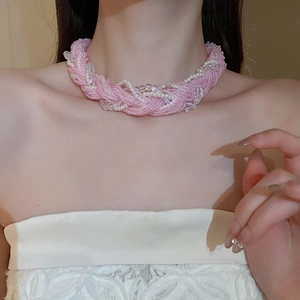 Detailed view of woven pink and white bead twisted necklace on model neckline