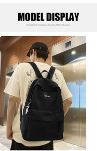 Detailed back view of a large black minimalist backpack with astronaut charm