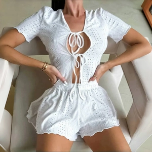 Two-piece white Broderie Anglaise lace pajama set with tie-front top and high-waist shorts