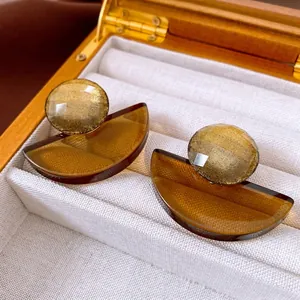 Retro geometric resin earrings featuring a gold metallic finish and amber half-circle drop
